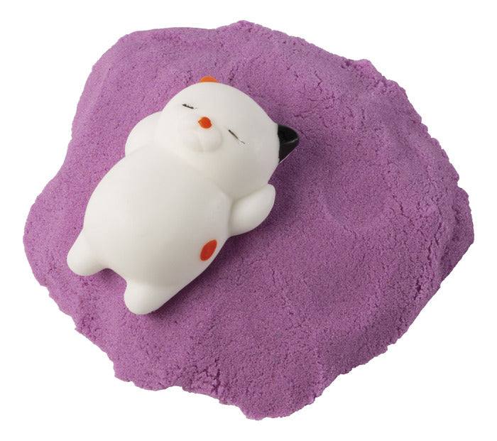 Laid back kitty figure resting on purple moldable sand in the Kitty Litter Box product set.