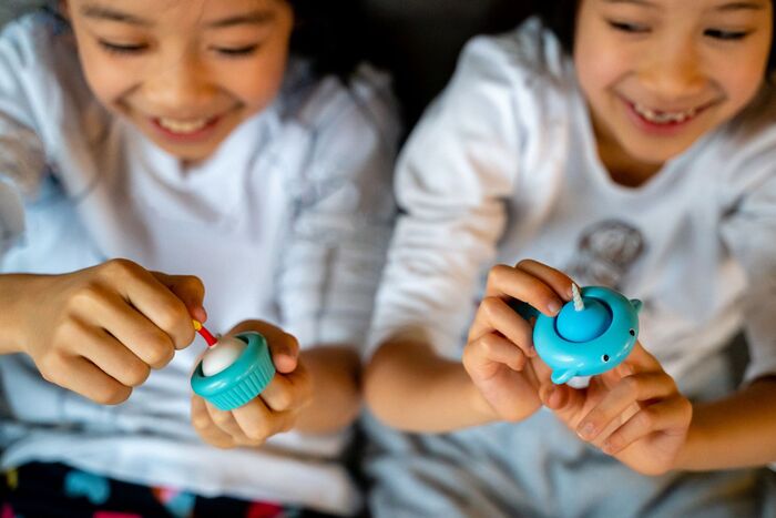 Two children playing with colorful Pull 'n Pops Keychain fidget toys, enjoying sensory popping and pulling.