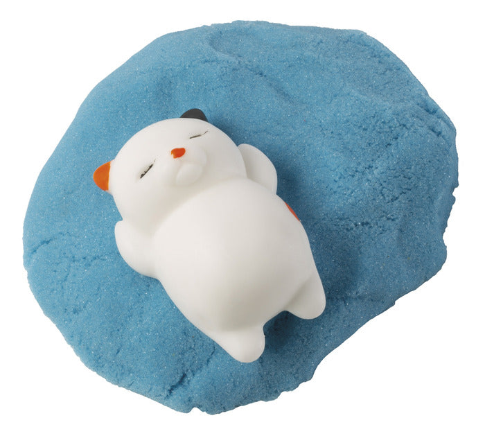 Laid back 2" squishy kitty resting on blue moldable sand in the Kitty Litter Box product set.