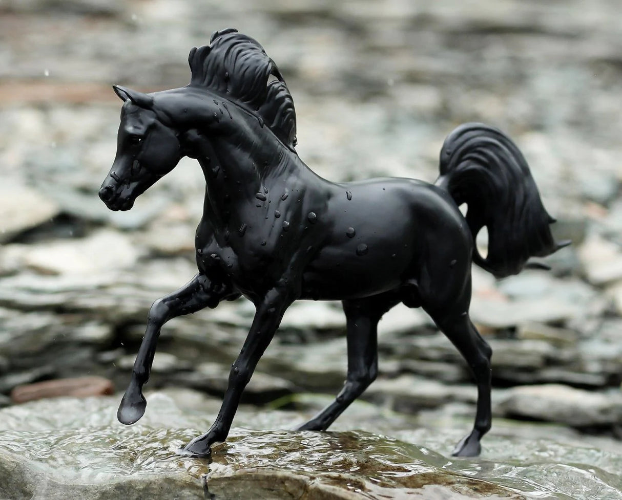Black Stallion with Book features a detailed 1:12 scale black horse figurine posed on natural rocks outdoors.