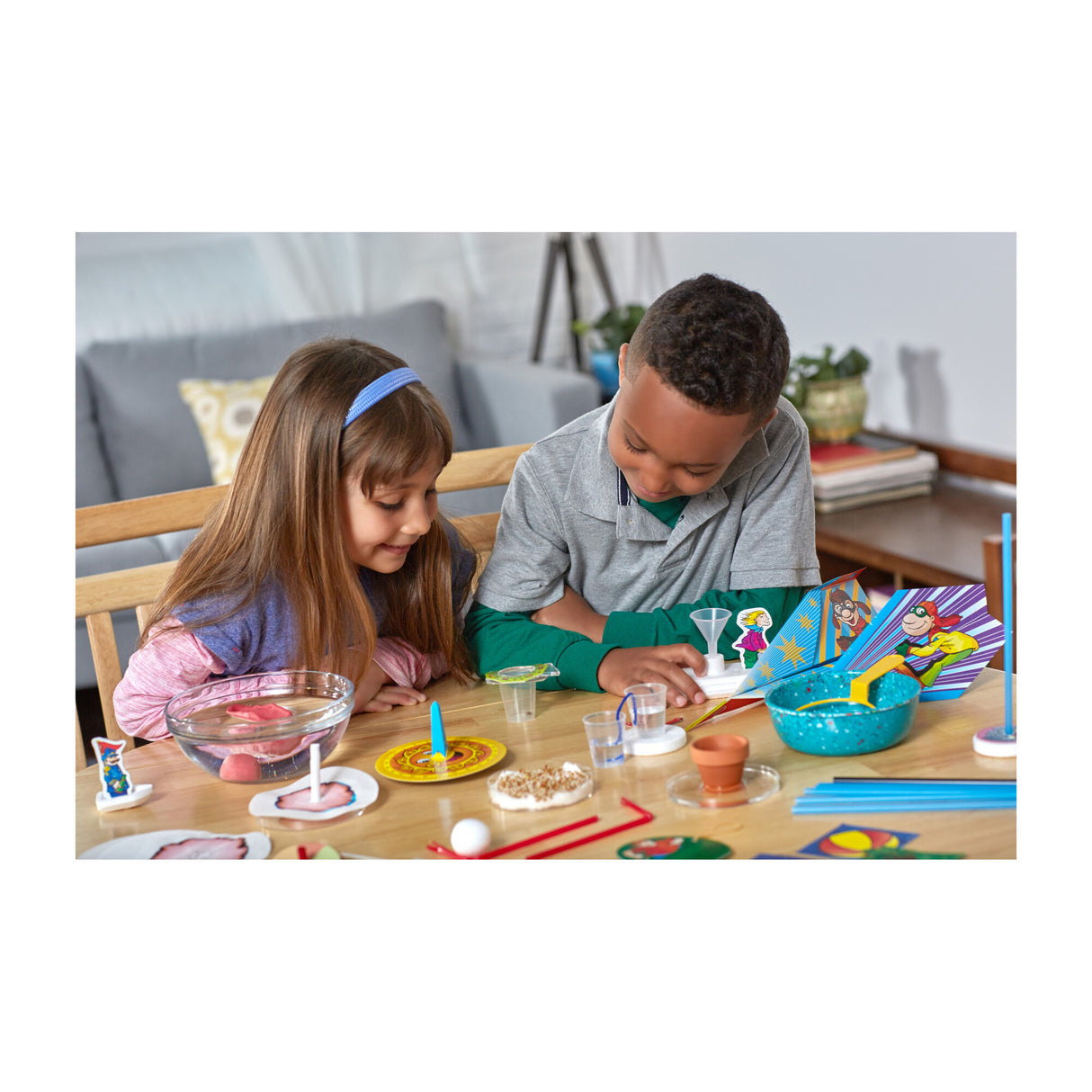 Two children engaged in hands-on experiments with educational tools using Stepping into Science kit at home.