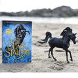 Black Stallion with Book showing the 75th anniversary edition and a detailed black stallion figure on a sandy beach.