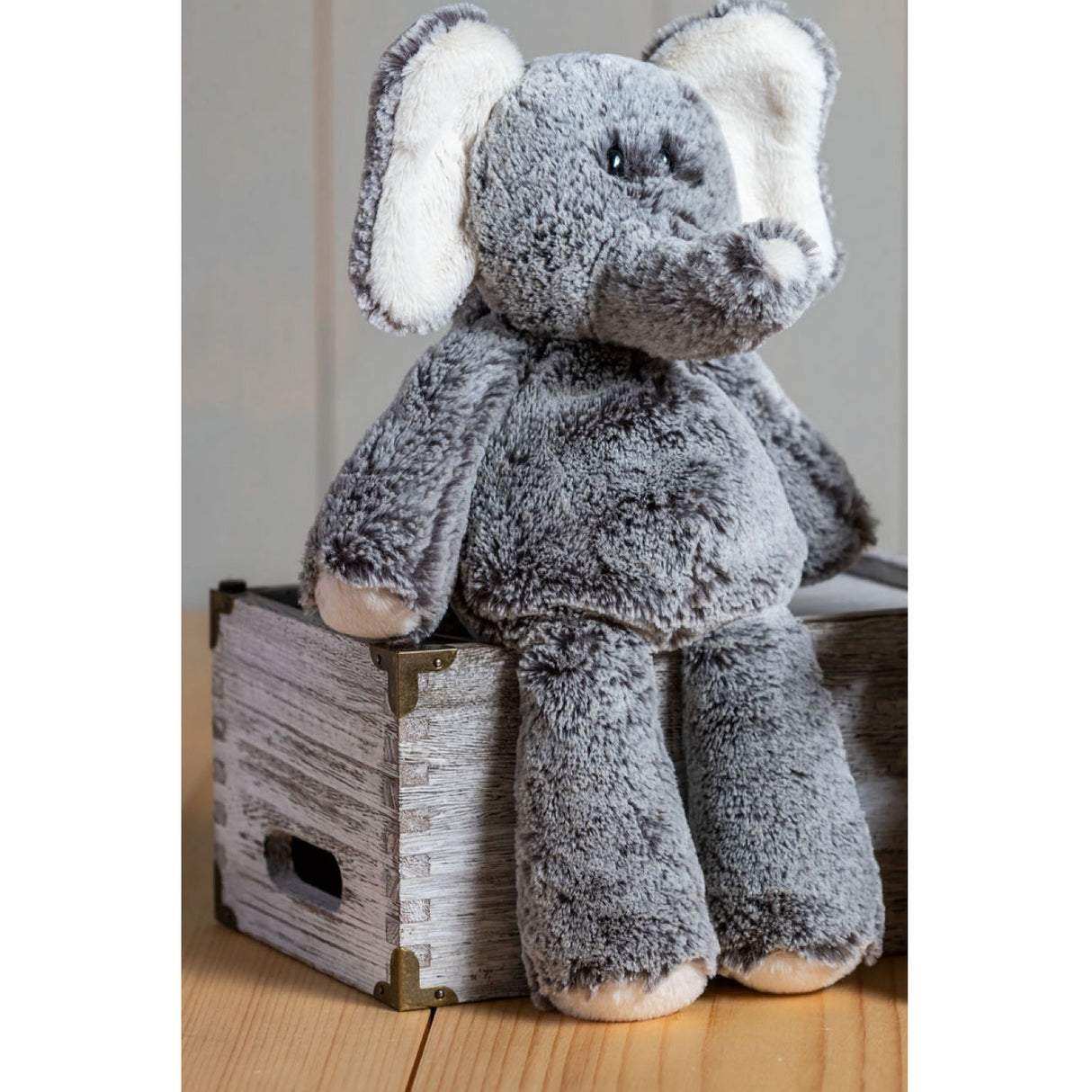 Plush Marshmallow Elephant sitting on wooden crate, featuring soft fabric and embroidered details for cuddly comfort.