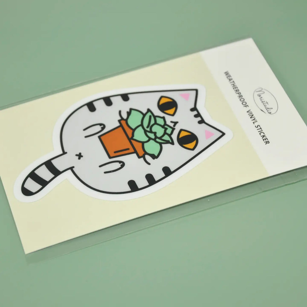 Gray Tabby Cat and Plant Sticker showing a cute gray tabby cat holding a potted plant vinyl sticker.