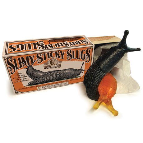 Open box of Slimy Sticky Slugs with two slugs coming out of the box, one transparent orange and one black. For ages 3 and up.