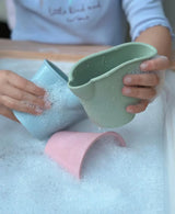 Child playing with pastel colored Scrunch Mini Bath Buckets in a bubbly bath, 3 pack of soft, flexible mini buckets.