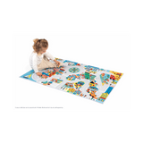 Child playing on colorful Crossroads City Play Mat featuring roads, buildings, and vehicles for imaginative urban play.