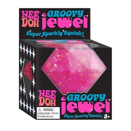 Bright pink glittery squishy jewel toy in black packaging labeled Nee Doh Groovy Jewel for kids ages three and up