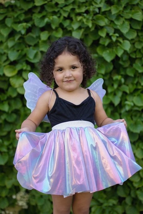 Young girl wearing the Magical Unicorn Skirt & Wings set with shimmery rainbow skirt and bluish purple wings.