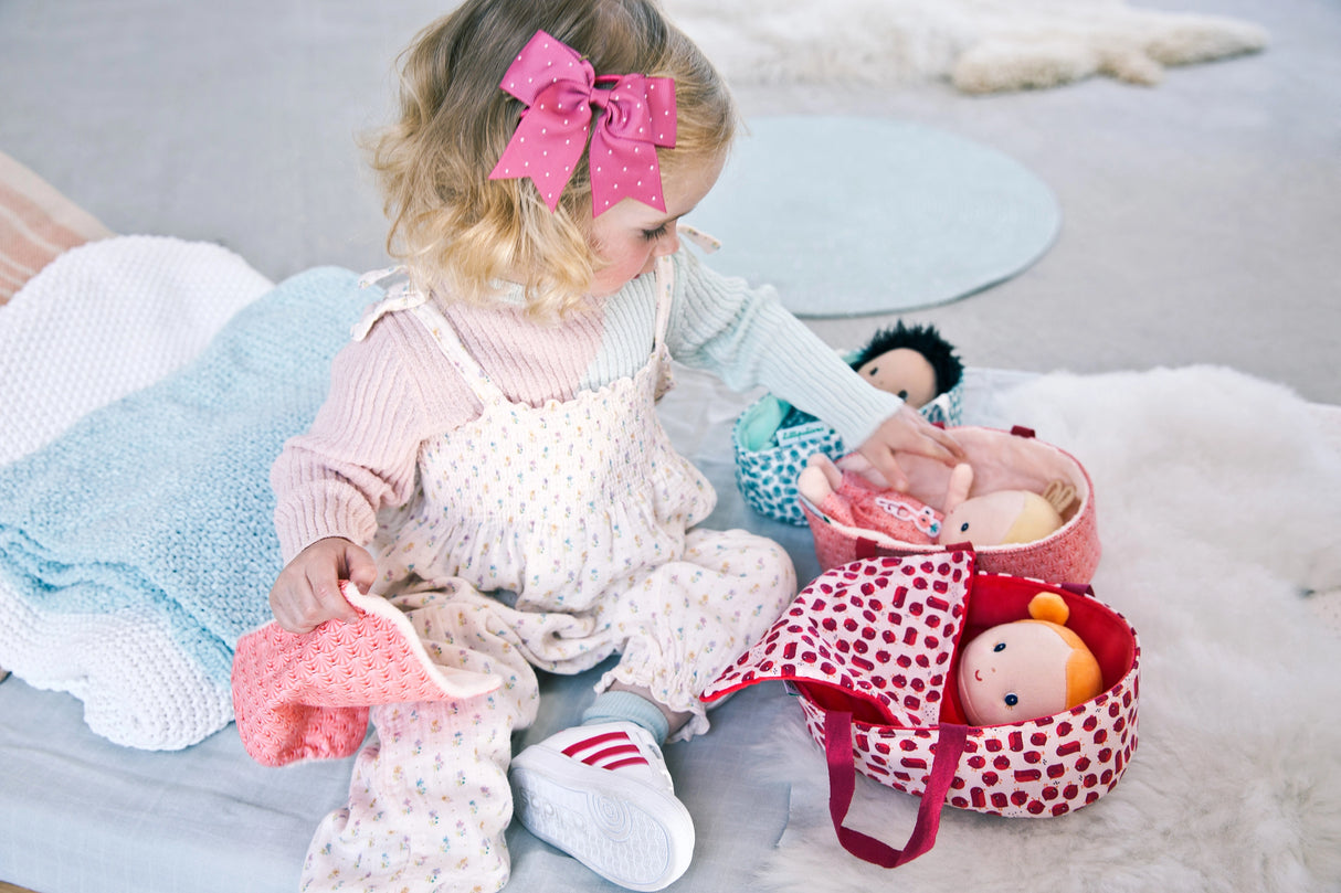 Little girl playing with Baby & Carrier | Agathe doll, dressing and caring for her in a cozy playroom setting.