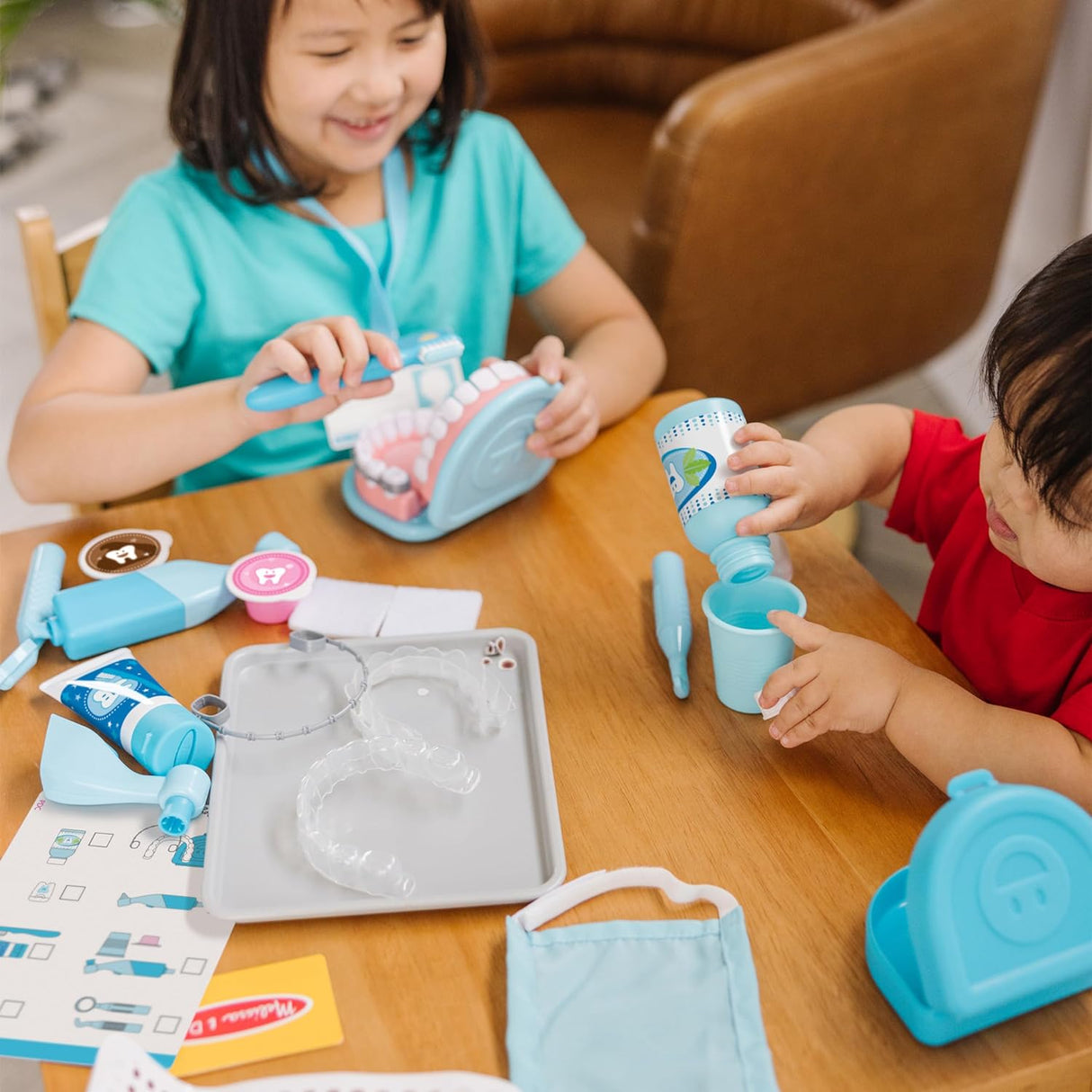 Children playing with dental tools and oversized teeth for cleaning in the Super Smile Dentist Play Set.