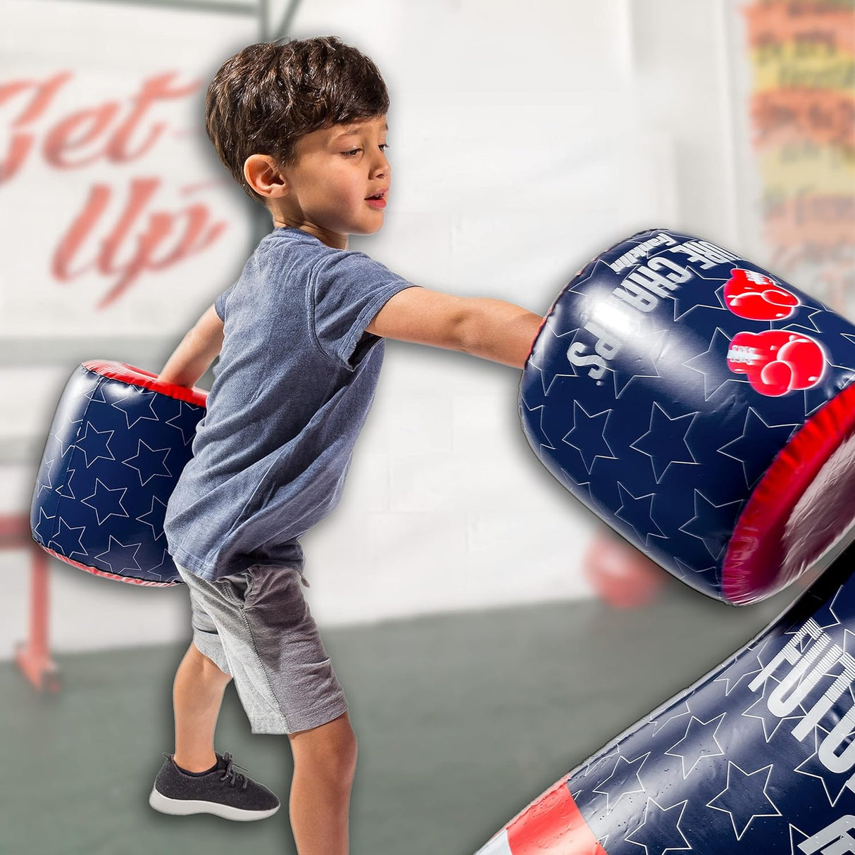 Young boy practicing boxing with the Punching Bag & Gloves inflatable set for kids training and fun.