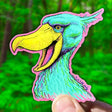 A colorful Shoebill Stork Sticker held in hand, featuring vibrant art by Ryan McCulloch, durable and waterproof.