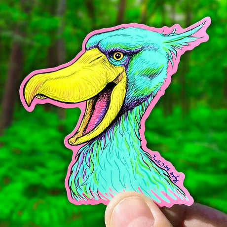 A colorful Shoebill Stork Sticker held in hand, featuring vibrant art by Ryan McCulloch, durable and waterproof.