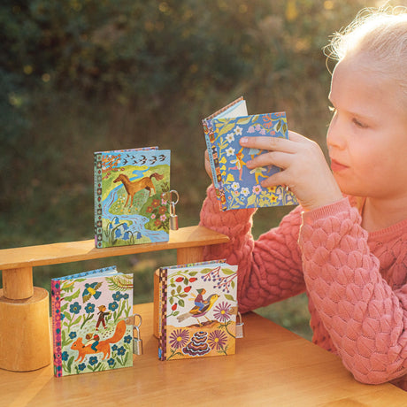 Very Small Journal | Gemma pocket-sized journals with fairy illustrations, metal locks, and sustainable materials on wooden table.