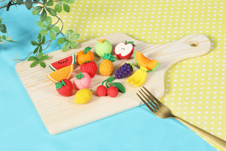 Japanese Eraser Fruit small puzzle erasers shaped like various fruits on a wooden cutting board with a fork nearby
