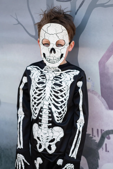 Child wearing Skeleton Outfit | Size 5-6 with detailed skeleton print and matching skull mask against a Halloween backdrop.
