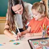 Mother and daughter coloring garden-themed designs for Shrink-Its! Garden Pals DIY shrink art charm kit.