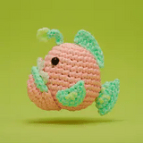 Handcrafted crochet angler fish with glow-in-the-dark yarn and adorable detailed stitches on green background