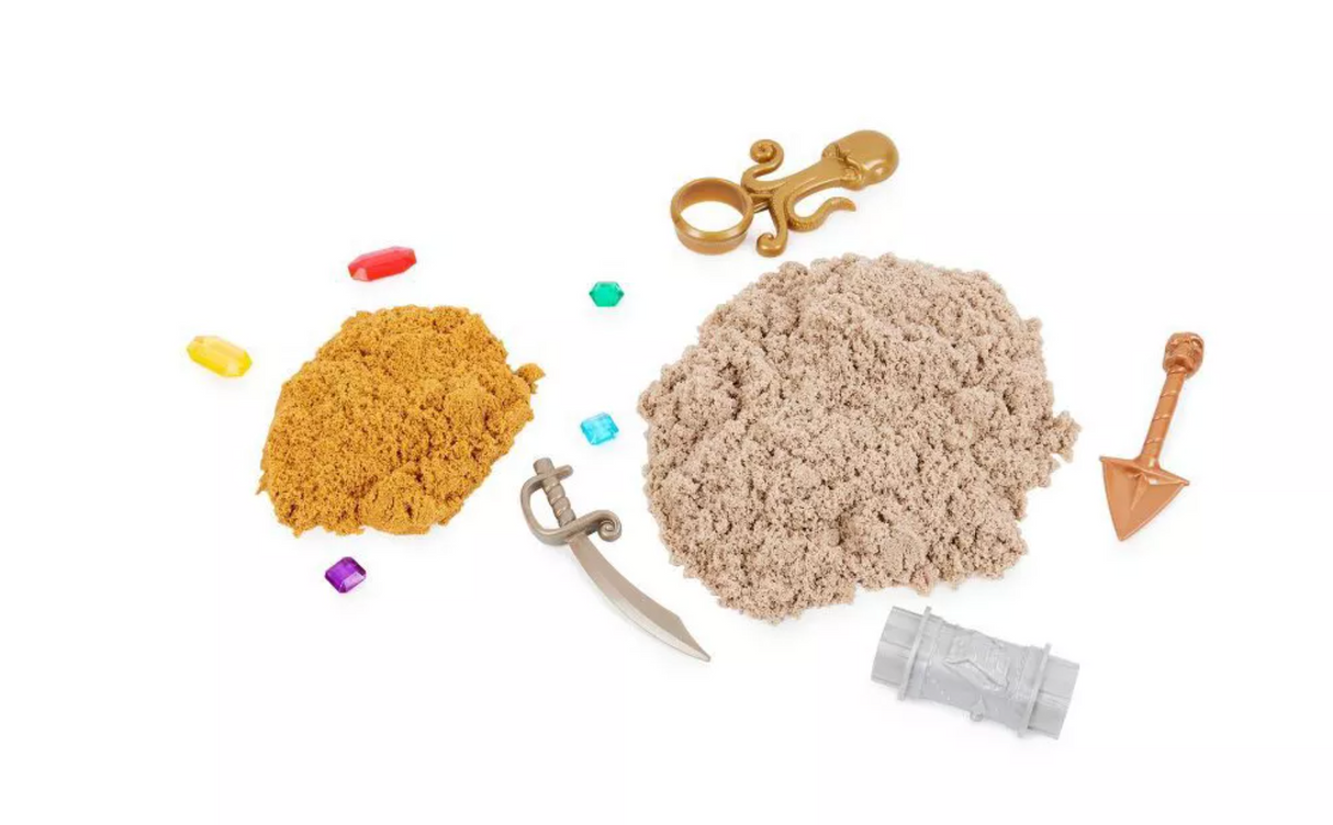 Kinetic Sand Treasure Hunt showing brown and gold kinetic sand with pirate tools, gems, and treasure hunt accessories.