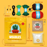 Complete crochet kit for Otis the Snake Plant with yarn, hook, stuffing, needle, eyes, and step-by-step instructions.