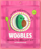Pink packaging of The Woobles Mateo the Avocado crochet kit with an image of the crocheted avocado on a decorative plate