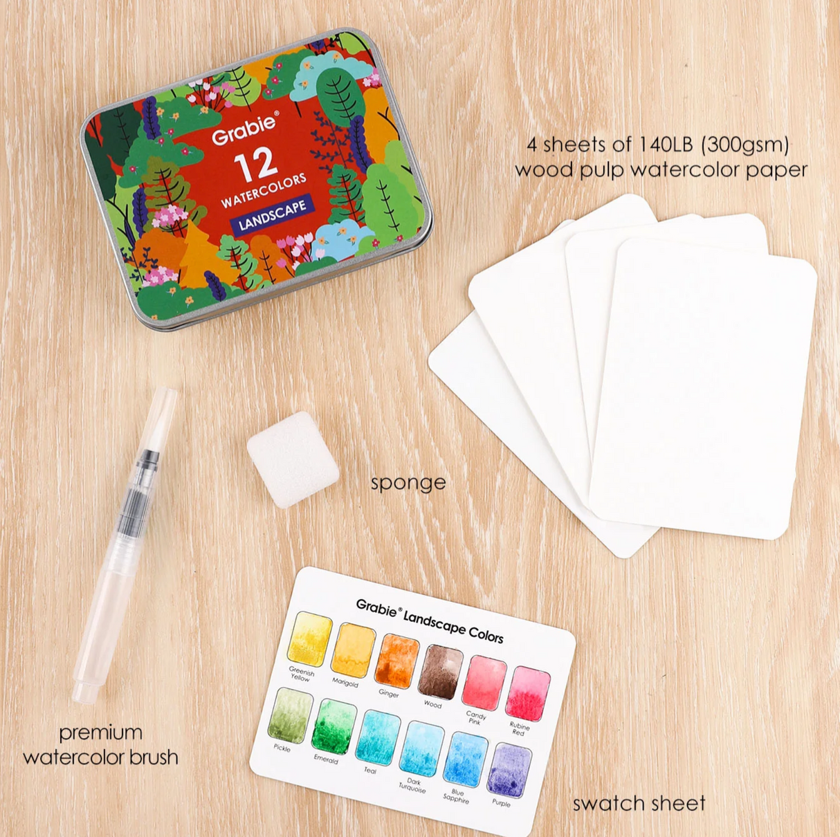 Compact Grabie watercolor set with 12 landscape colors, brush, sponge, swatch sheet, and four sheets of premium paper