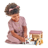 Child playing with The Stables toy set featuring ponies, stable, brush, and accessories for imaginative grooming play.