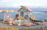 Sandy's Beach Hut wooden toy set featuring seagulls, fish and chips stall, beach accessories, and imaginative play scene.