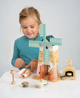 Child playing with Penny Windmill wooden toy featuring mice, oven, and accessories for imaginative play.