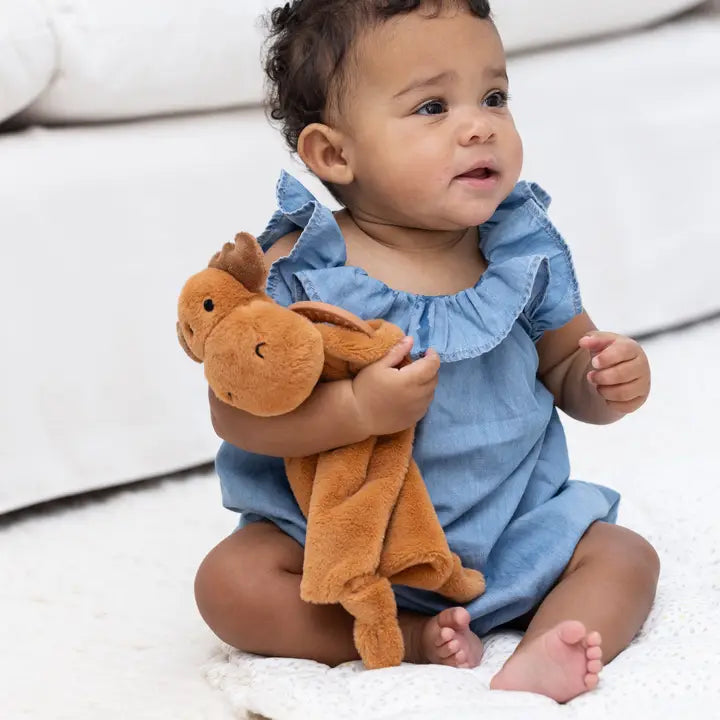 Baby holding the Teether Buddy | Max the Moose plush toy with teething rings and soft faux fur.