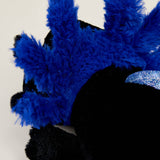 Close-up of a soft plush black axolotl with bright blue fluffy gills and a shiny blue accent on a light background