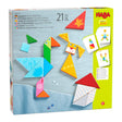 Colorful wooden tangram puzzle pieces with funny faces forming a bird, dog, and house on a play surface.
