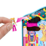 Hand holding Polly doll to place inside Polly Pocket Advent Calendar gingerbread house winter playset scene.
