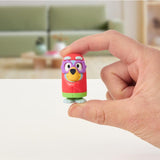 Hand holding a colorful mini figure from the Bluey Mini Figure Mystery Pack in a bright indoor setting.