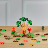 Plus Plus Jungle 240pc colorful building pieces creating a 3D tree and plants on a wooden surface.