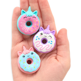 Hand holding three colorful Unicorn Donuts Puzzle Erasers with smiling faces and unicorn horns.