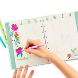A hand using Color Lustre Metallic Brush Markers to add bright, shimmering floral designs and reminders in a planner.