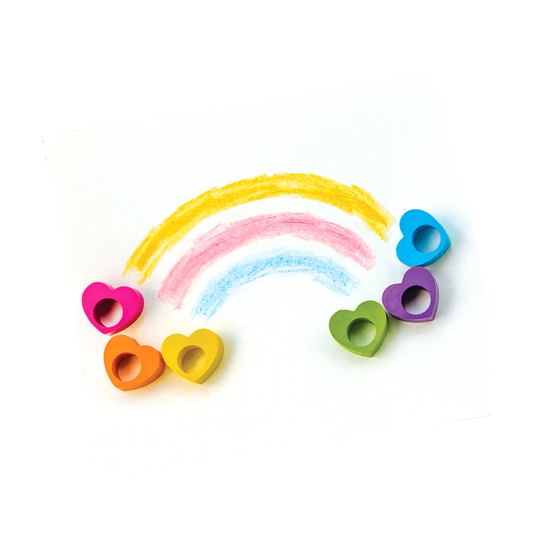 Heart Ring Crayons in six colors shaped like hearts, arranged with rainbow crayon drawings on white paper.