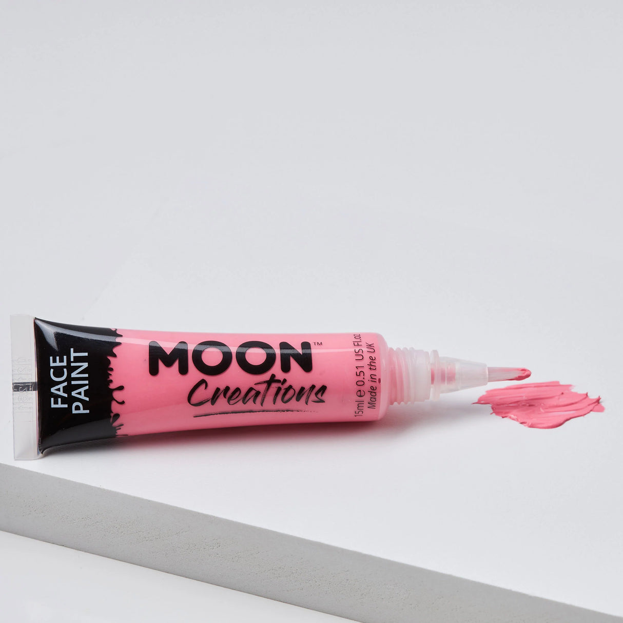 Face Paint Brush Tip - Adventure in pink with brush applicator and smooth paint stroke on white surface.