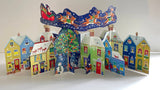 Santa's Rooftop 3D Advent Calendar showing a colorful Christmas town with Santa's sleigh flying above.