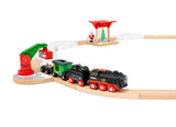 Steaming Christmas Train Set with battery-operated engine, snowy tracks, North Pole station, and Santa Claus figure on wooden train tracks.