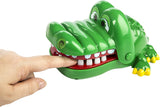 Crocodile Dentist game with a green crocodile toy snapping jaws as a finger presses its tooth toy.