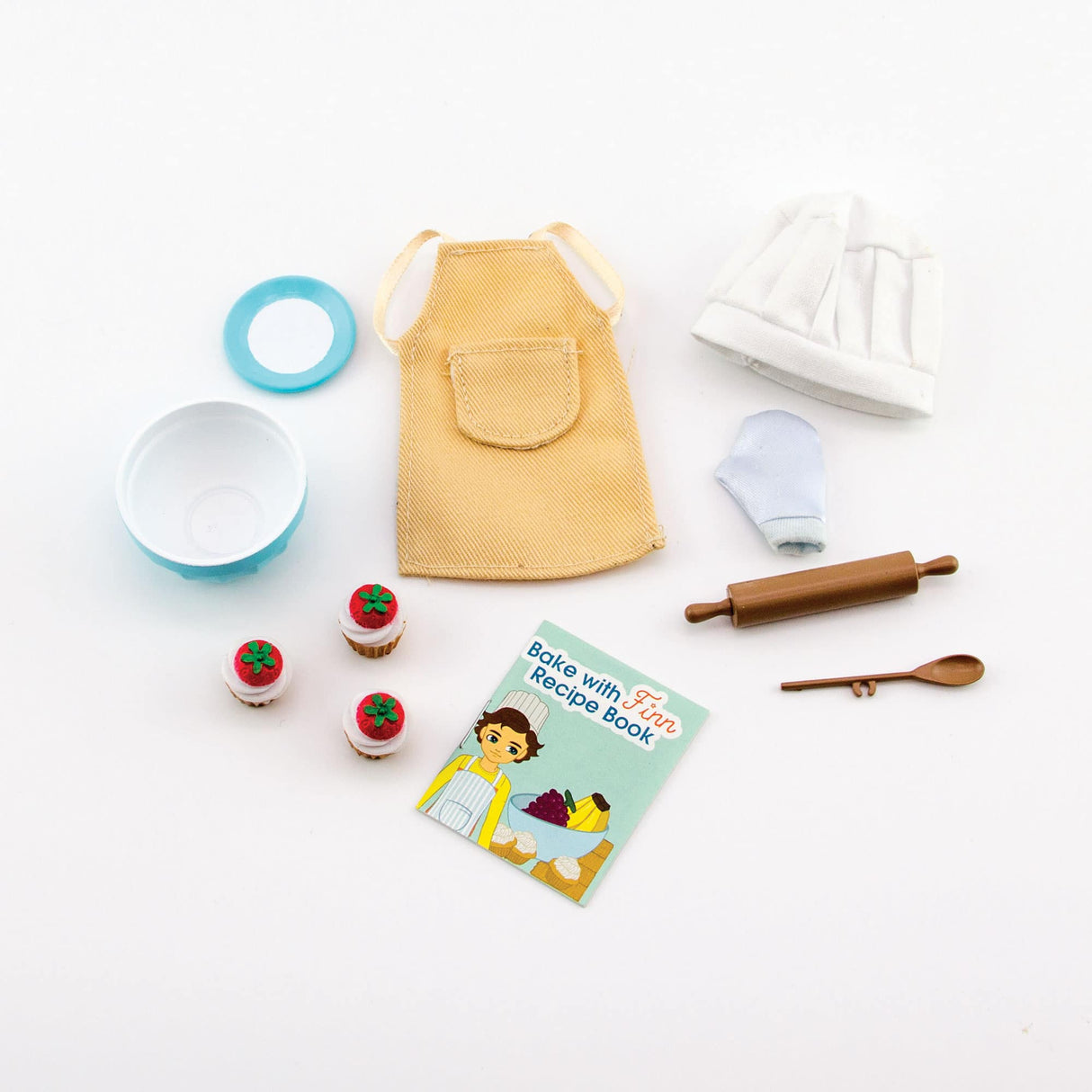 Lottie Cake Bake Outfit with doll chef hat, apron, oven mitt, rolling pin, mixing spoon, bowl, cupcakes, plate, and recipe book.