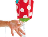 Happy Buckets Set red bucket with white polka dots pouring water over a child's hand for bath play.