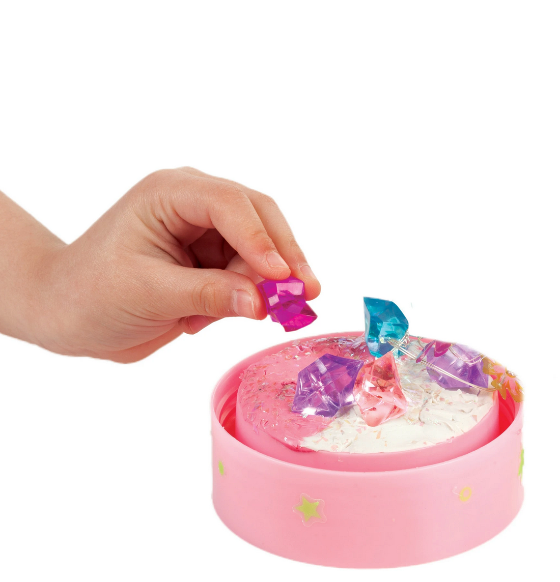 Hand placing colorful faux crystals onto clay in the Butterfly Fairy Lights crafting kit base.