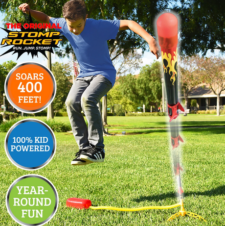 Boy stomping to launch the Stomp Rocket X-Treme! rocket outdoors, soaring high in sunny park grass.
