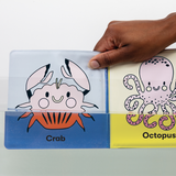 Bath Book Color Magic | Color the Ocean shows a hand dipping a crab page with color appearing underwater.