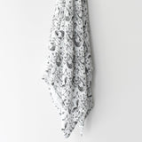 Organic Muslin Swaddle | Forest hanging, showing black and white forest animal pattern on soft organic cotton muslin fabric.